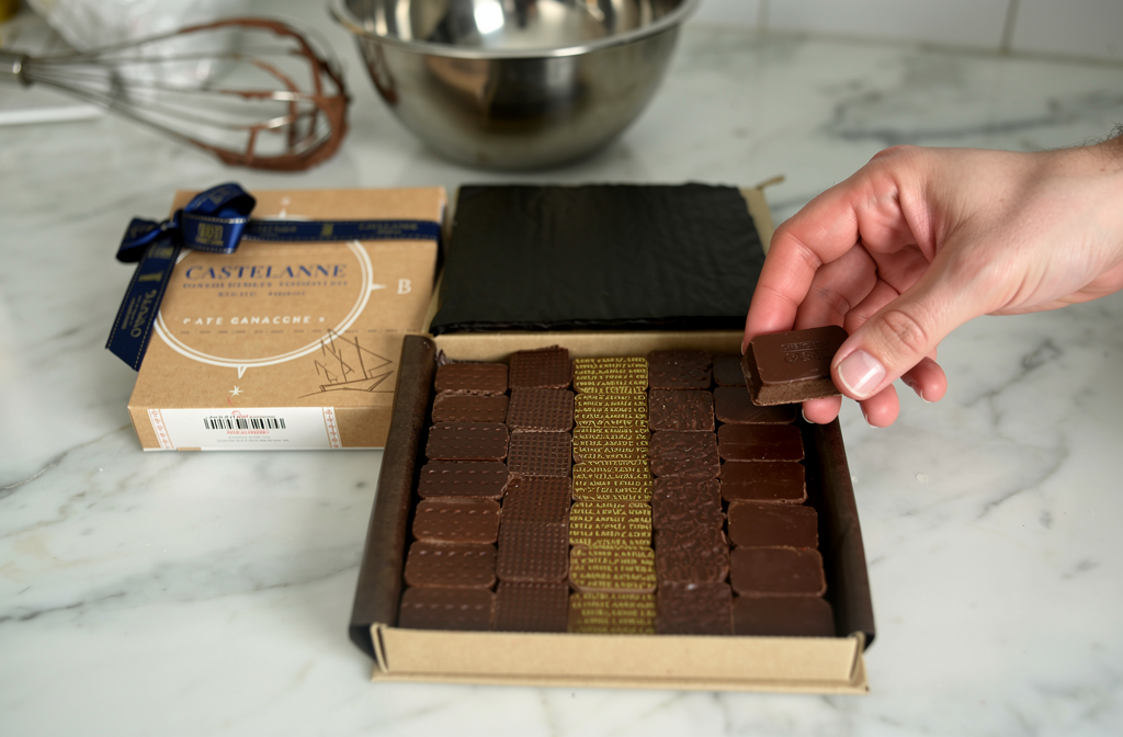 Chocolat Castelanne ouvert sur un plan de travail de cuisine prêt pour la préparation de ganache montée