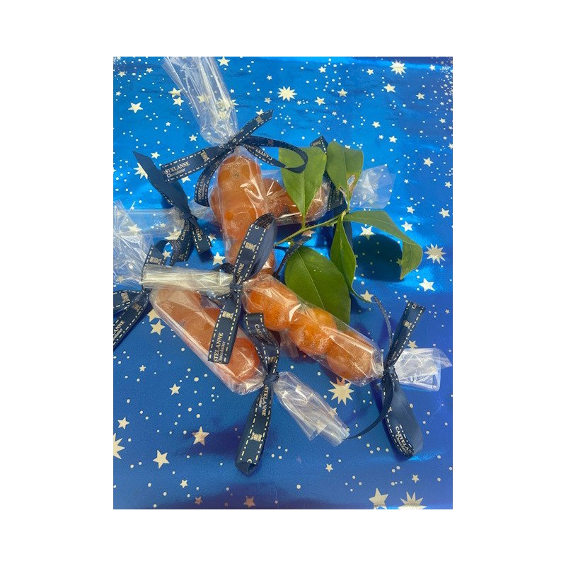 Bonbons chocolat orange enrobés, emballés individuellement dans du film transparent et liée de rubans noirs, sur fond bleu étoilé.