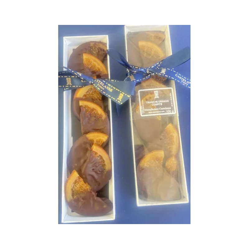 Boîtes cadeaux de chocolats artisanaux Castelanne, garnies de tranches d’orange confite sur chocolat, emballées avec rubans bleus.