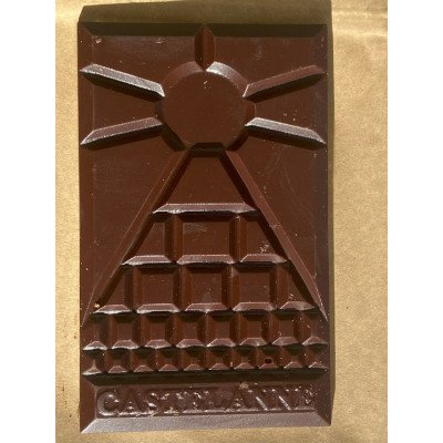 Tablette de chocolat sombre avec sculpture géométrique gravée, motif pyramidale et nom CASTELANNE en relief en bas.